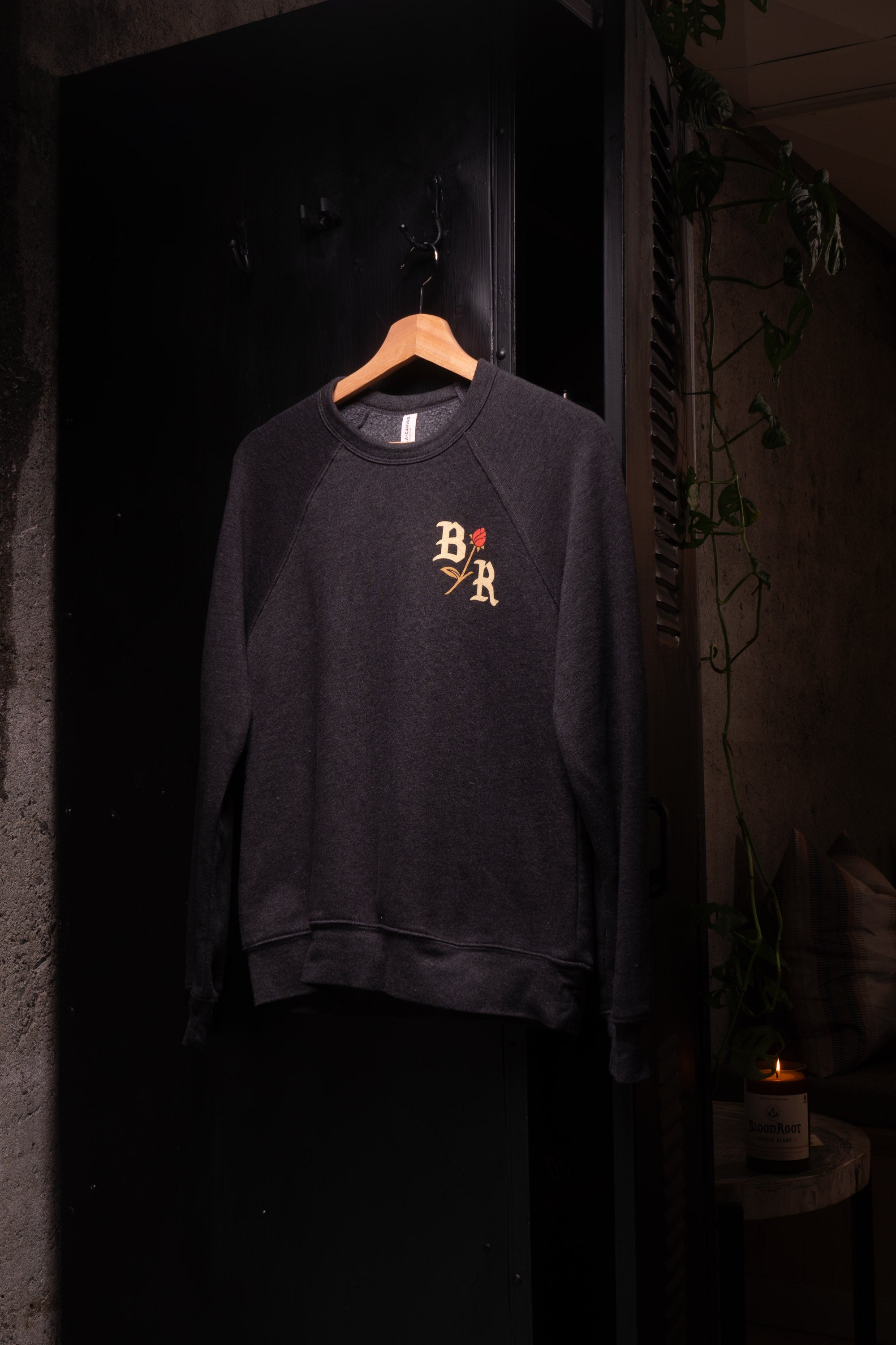 Letters BR with rose design on front of dark gray crew neck sweatshirt