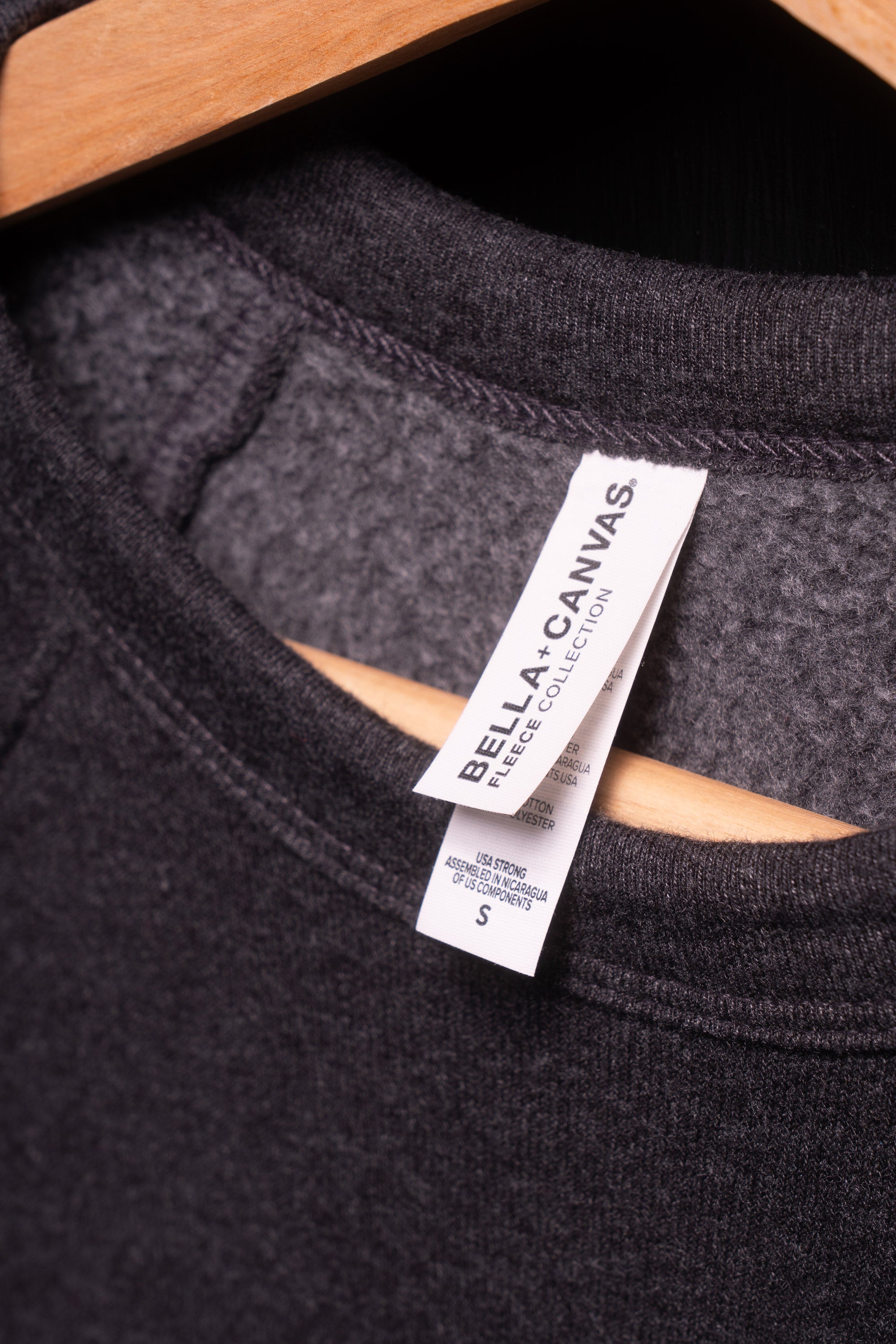 Bella + Canvas tag inside neck of gray crew neck sweatshirt