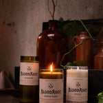 Group of BloodRoot candles lit with used match laying in front