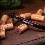 Black corkscrew with white BloodRoot logo with wine corks
