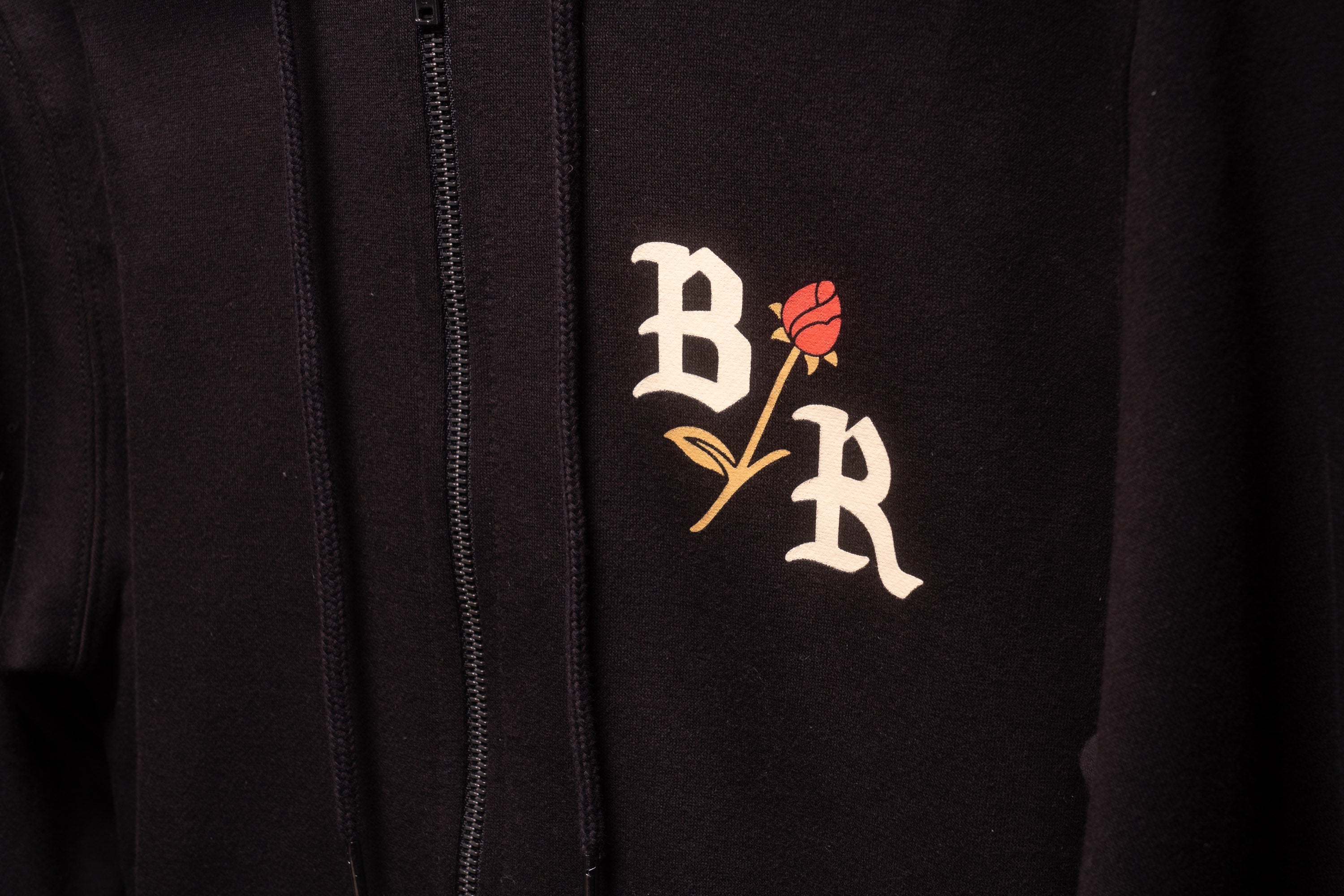 Front of BloodRoot zip up hoodie featuring BR with rose design