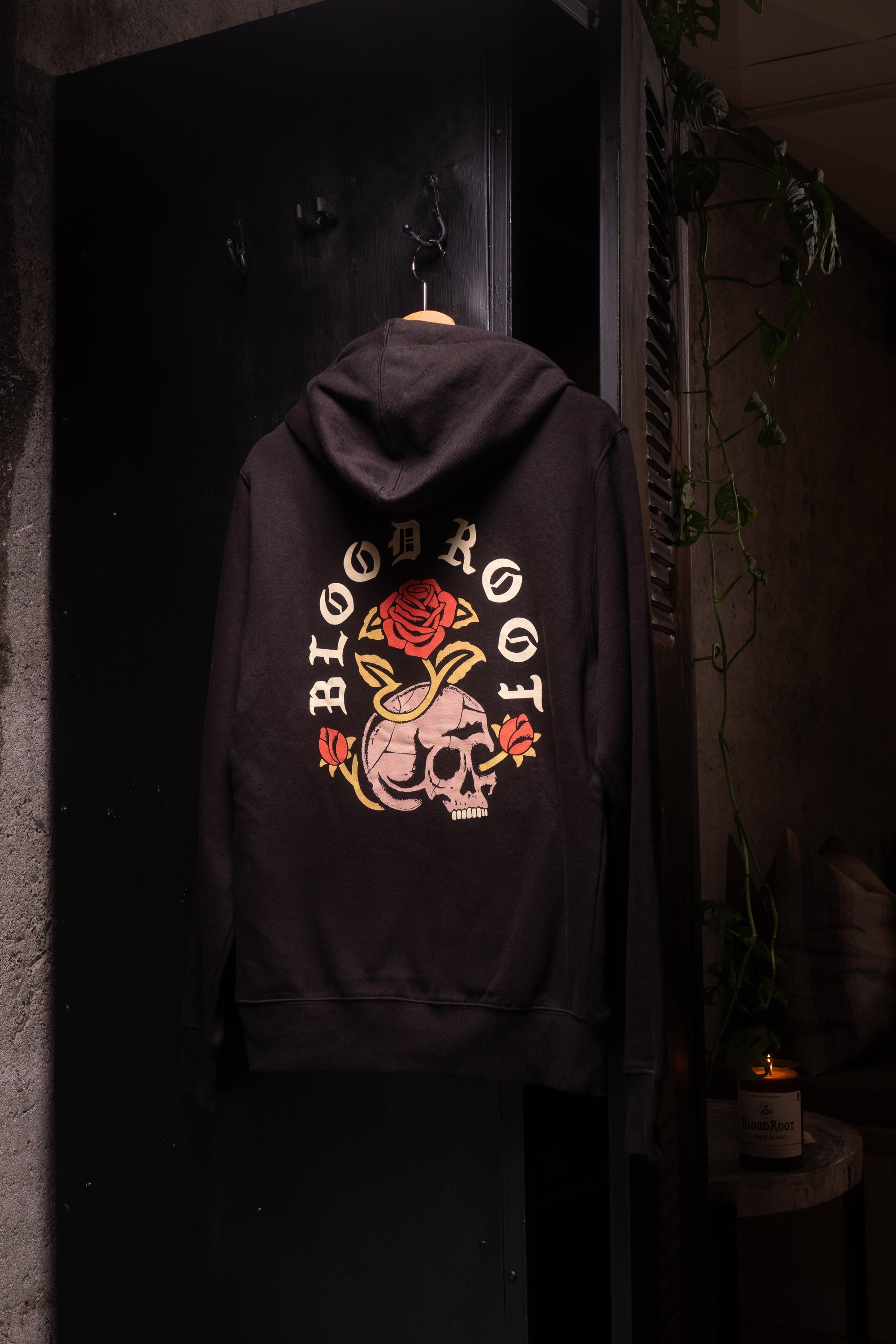 BloodRoot Skull and Roses design in white and red on the back of black hoodie
