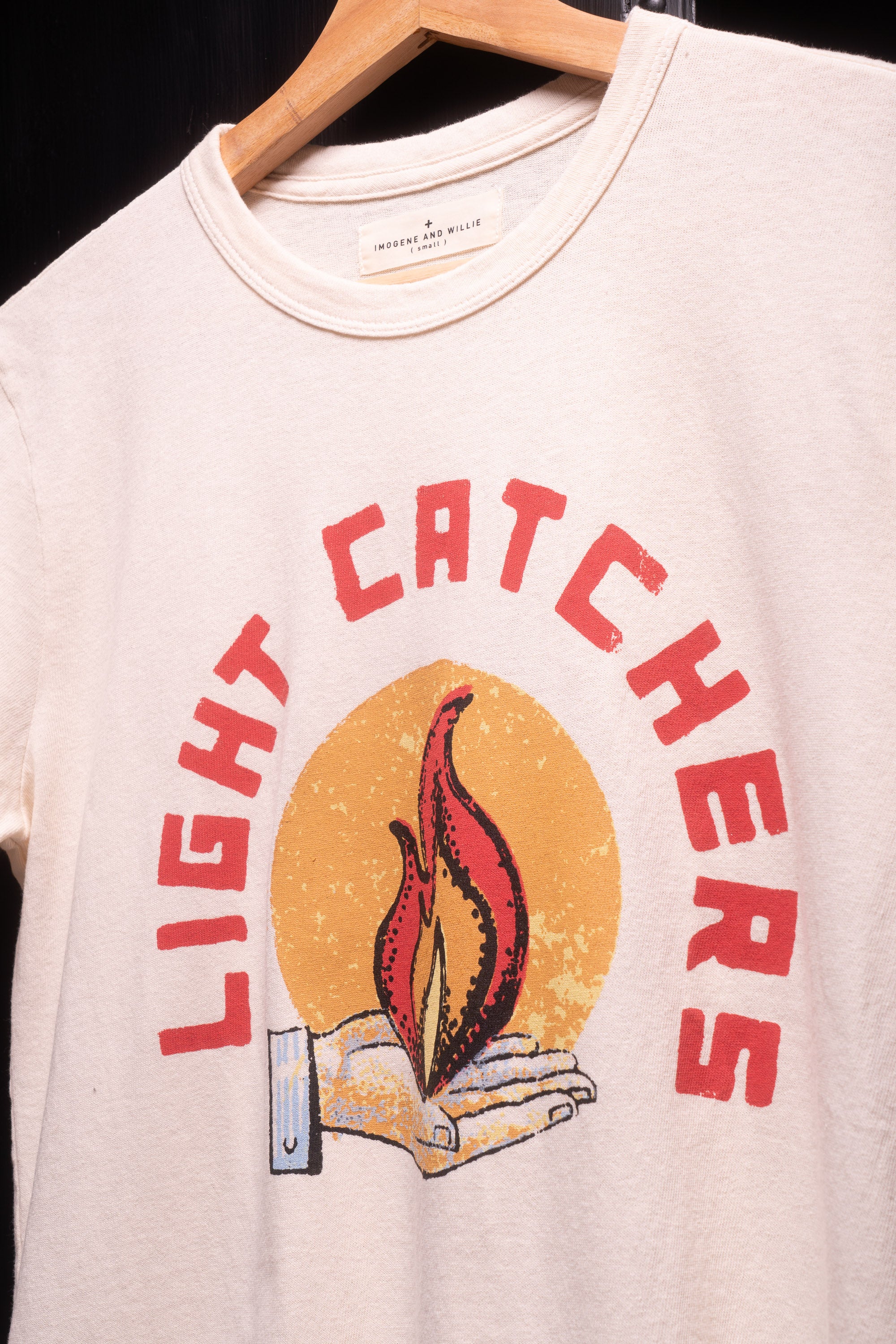 Close up view of light catchers logo on white t-shirt