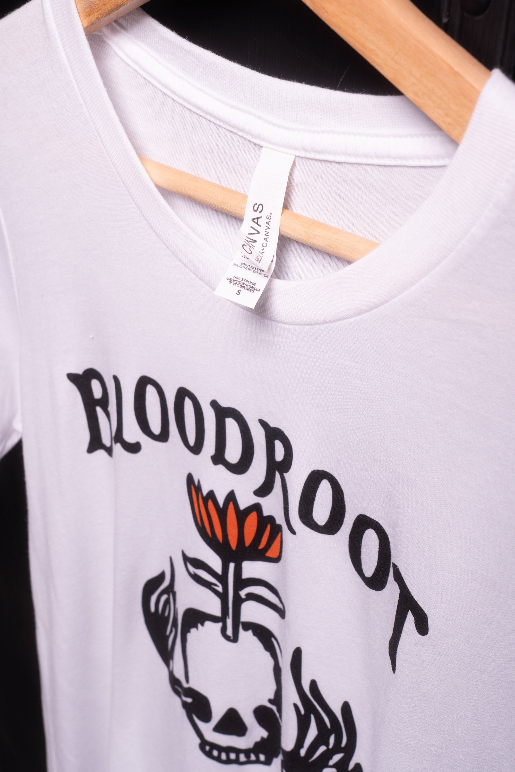 Front view of white BloodRoot t-shirt with black logo featuring Bella Canvas tag